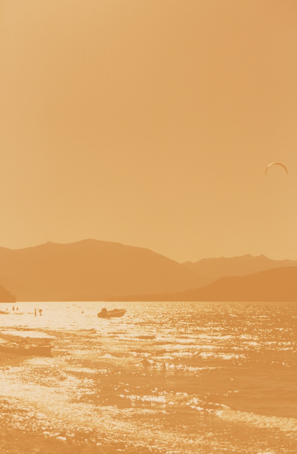 a couple of people standing on top of a beach next to the ocean