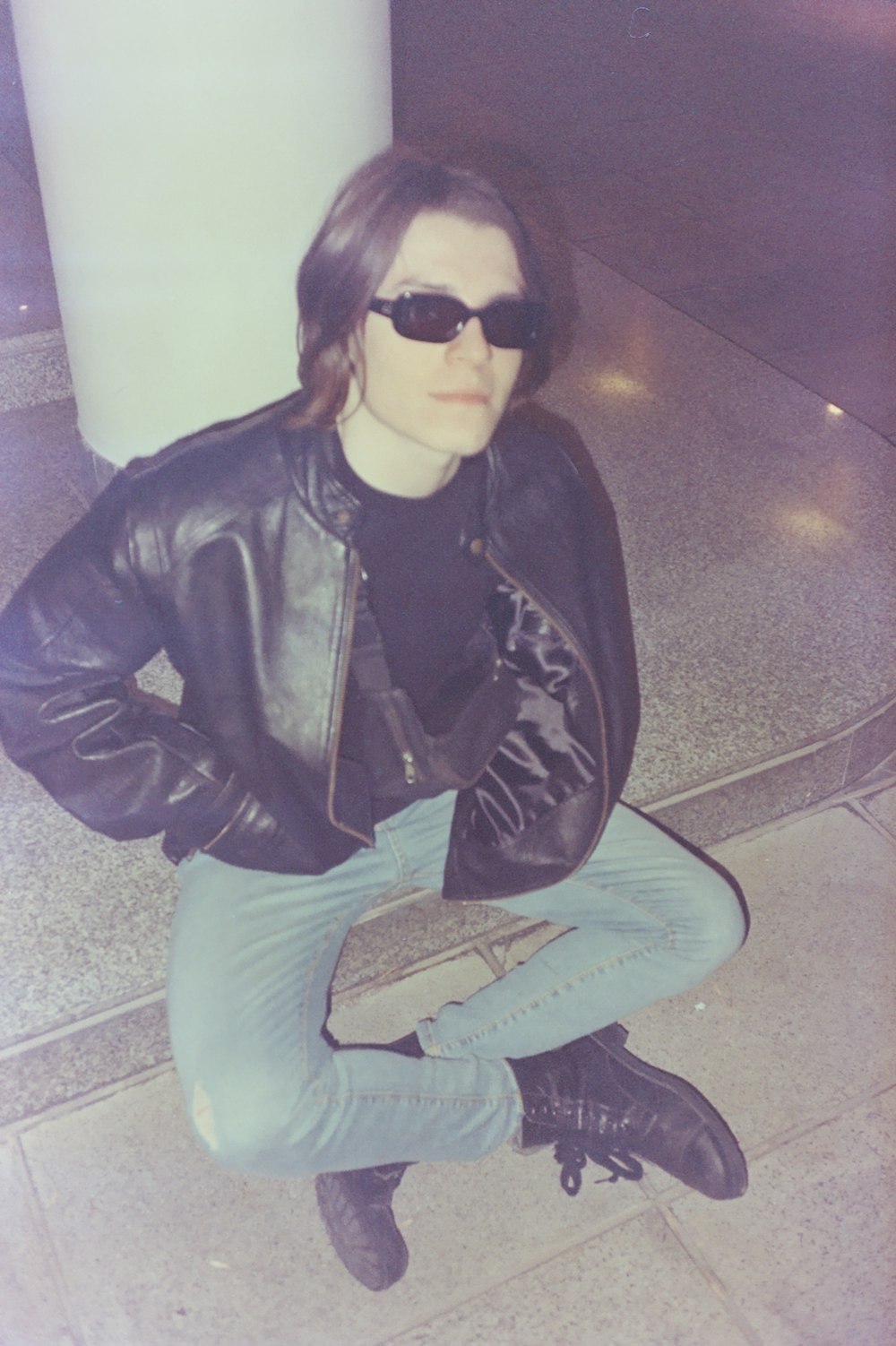 a man sitting on the ground wearing sunglasses