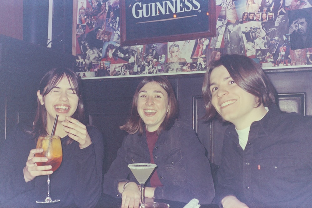 three women sitting at a table with drinks