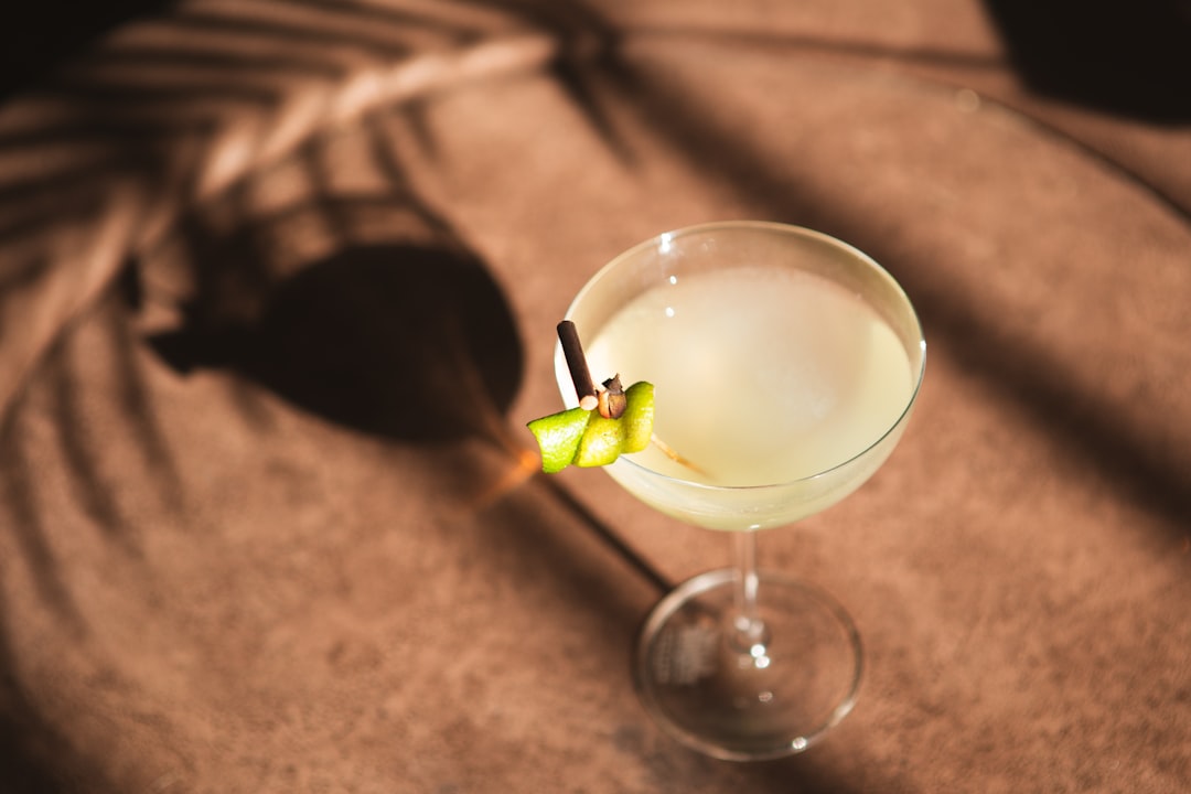 a glass filled with a drink sitting on top of a table,