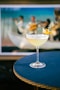 a martini sitting on top of a table next to a tv