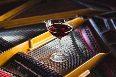 a glass of wine sitting on top of a piano