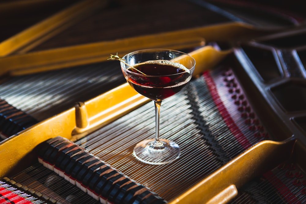 a glass of wine sitting on top of a piano