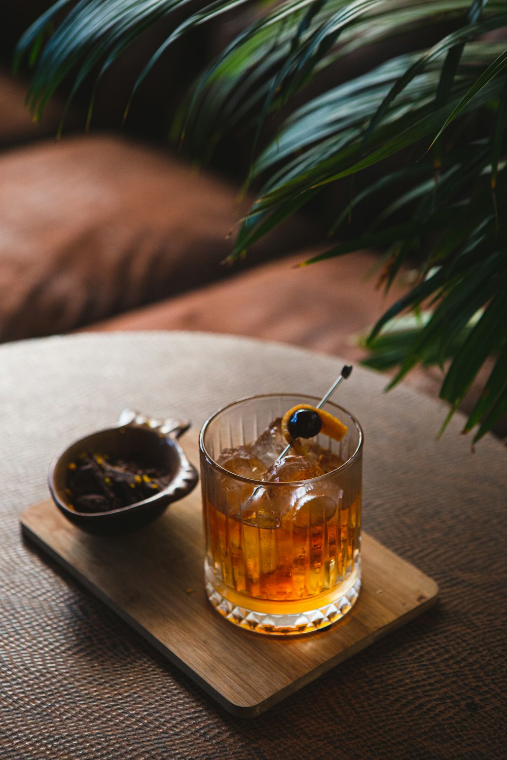 a glass of alcohol and a plate of food on a table