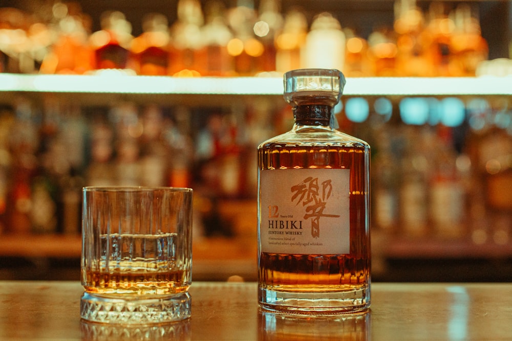 a bottle of whisky sitting next to a glass