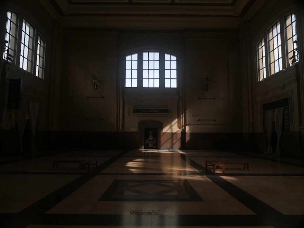 a dimly lit room with two large windows