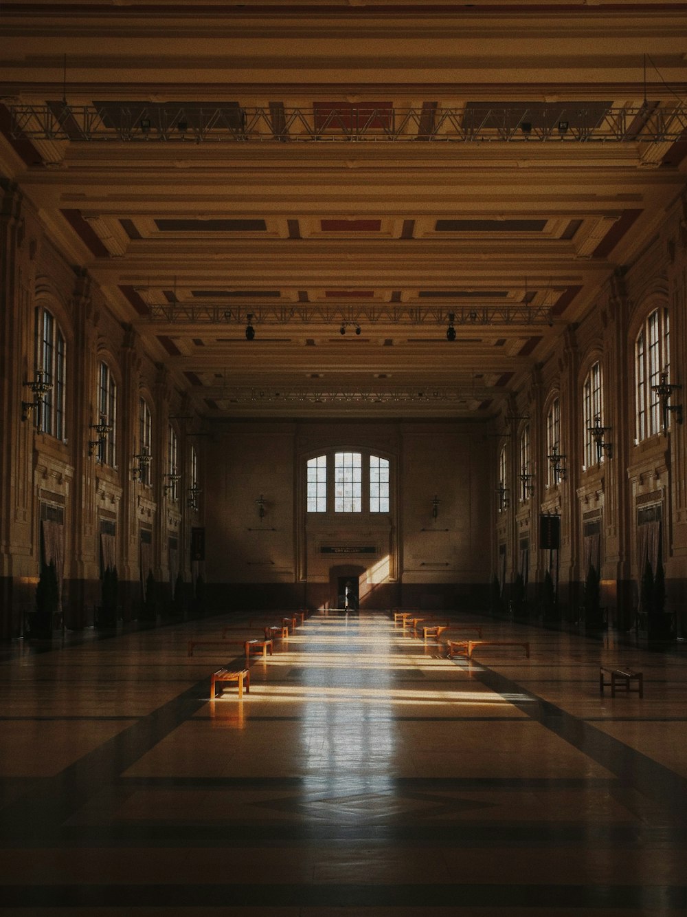 an empty hall with benches and windows