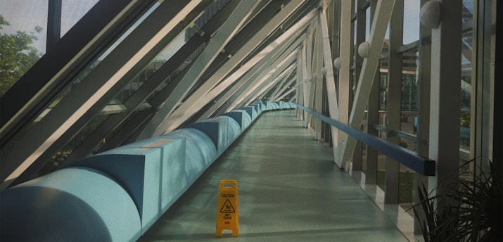a long hallway with a yellow caution sign on the floor