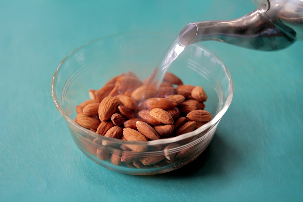 a glass bowl filled with almonds on top of a table