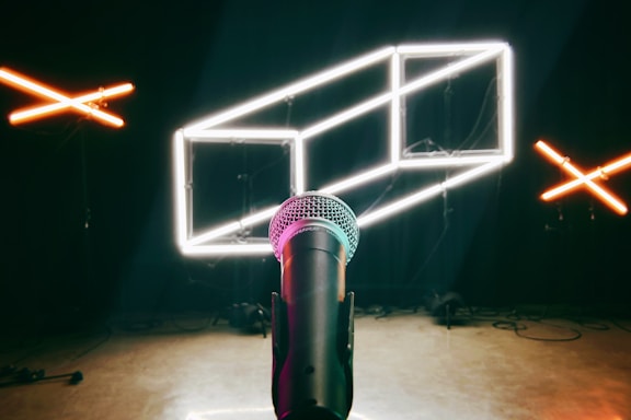 A sleek neon-lit microphone with animated jungle characters dancing around it.