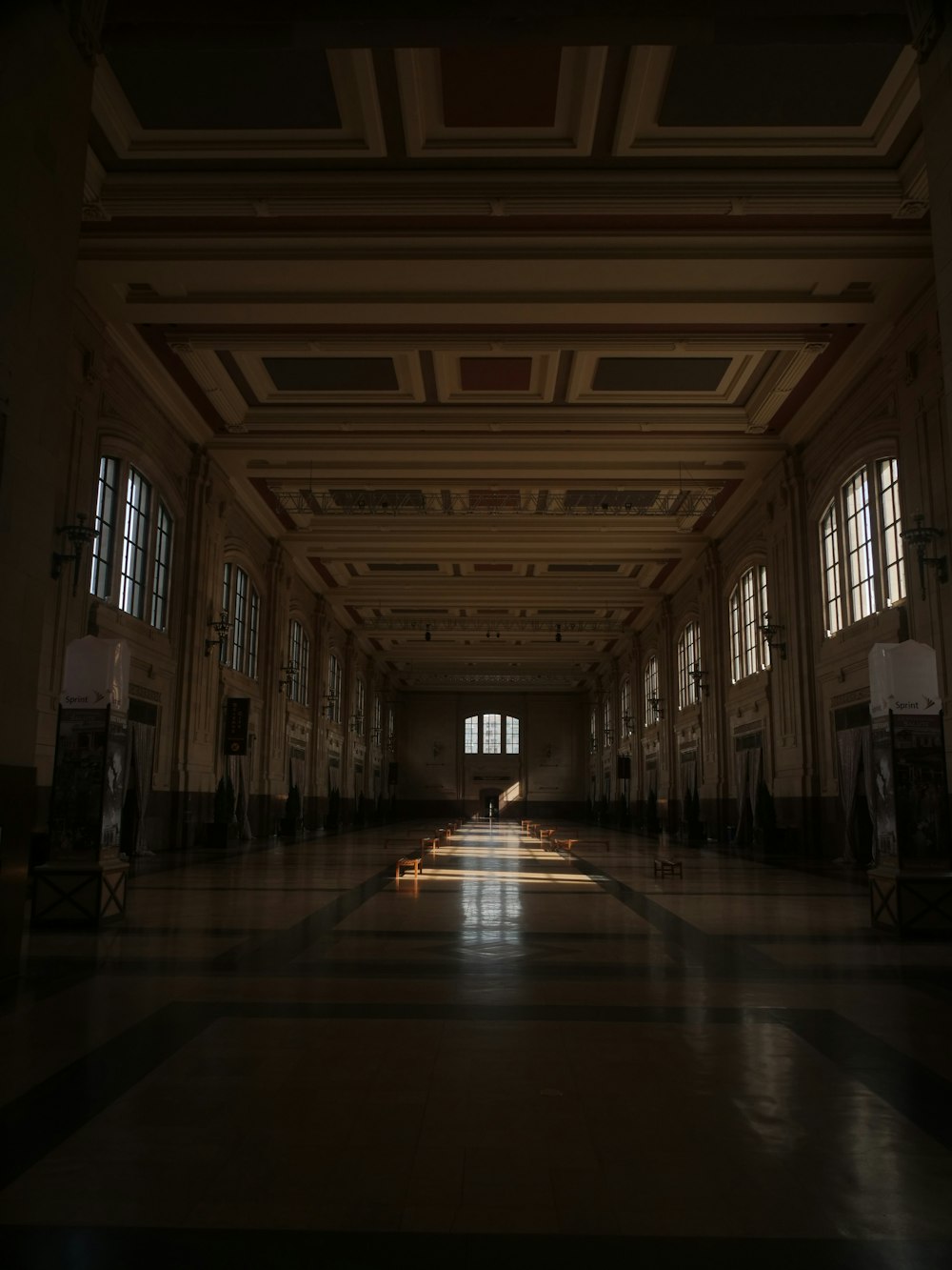 a long hallway with two windows and a tiled floor