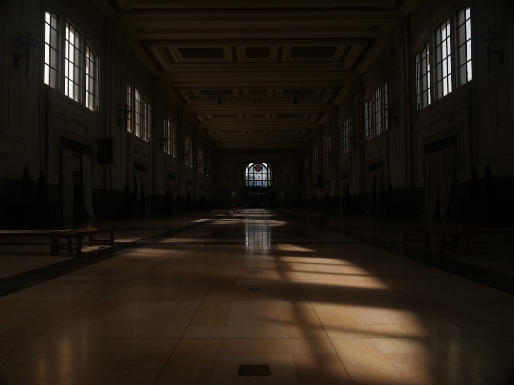 a long hallway with windows and benches in it