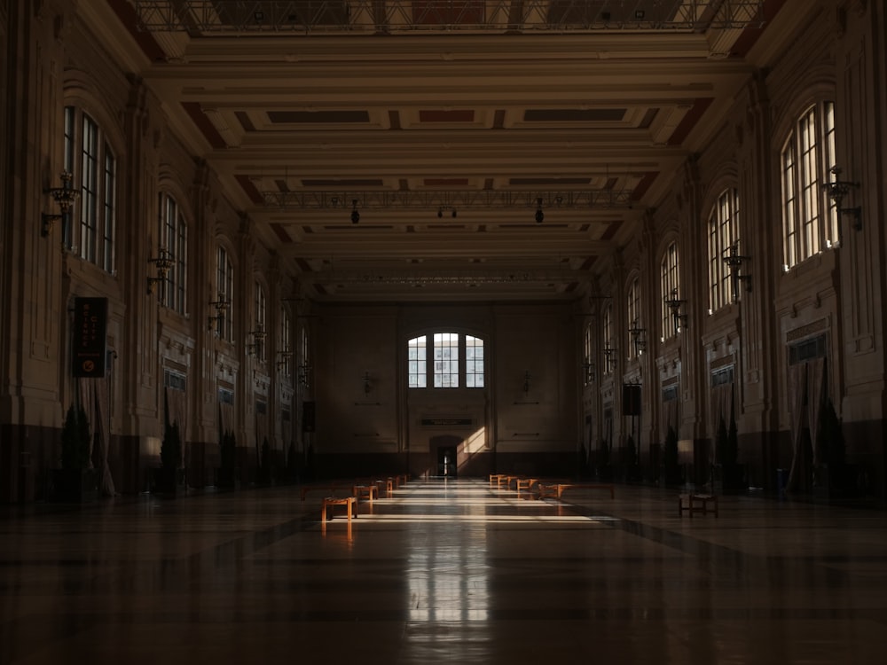 an empty hall with benches and windows