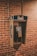 an old style pay phone in front of a brick wall