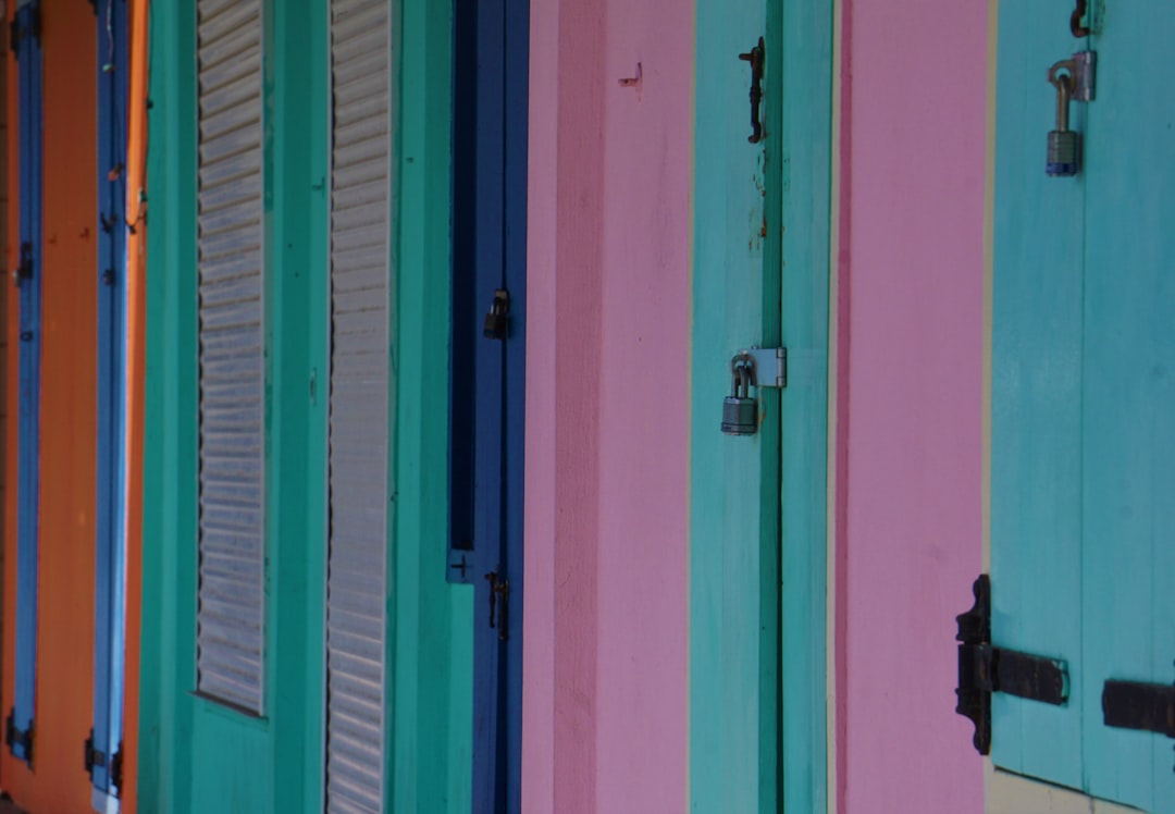 a row of multicolored doors on a building,