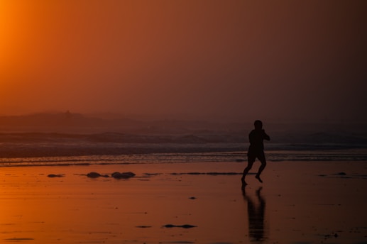 Sunset run along Malaga's beach with a group of smiling athletes.