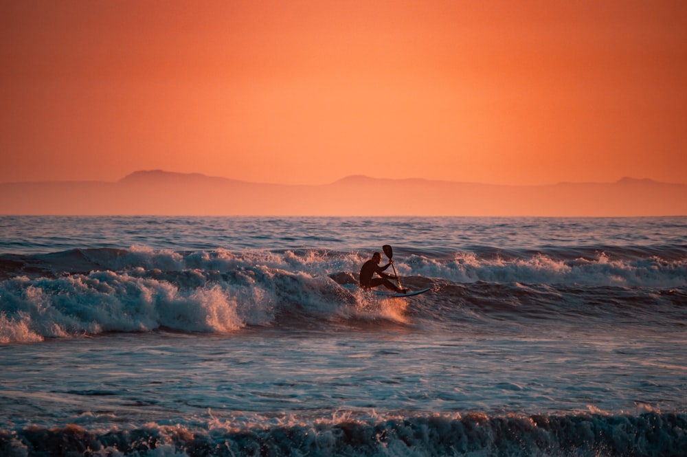 a person riding a surfboard on a wave in the ocean