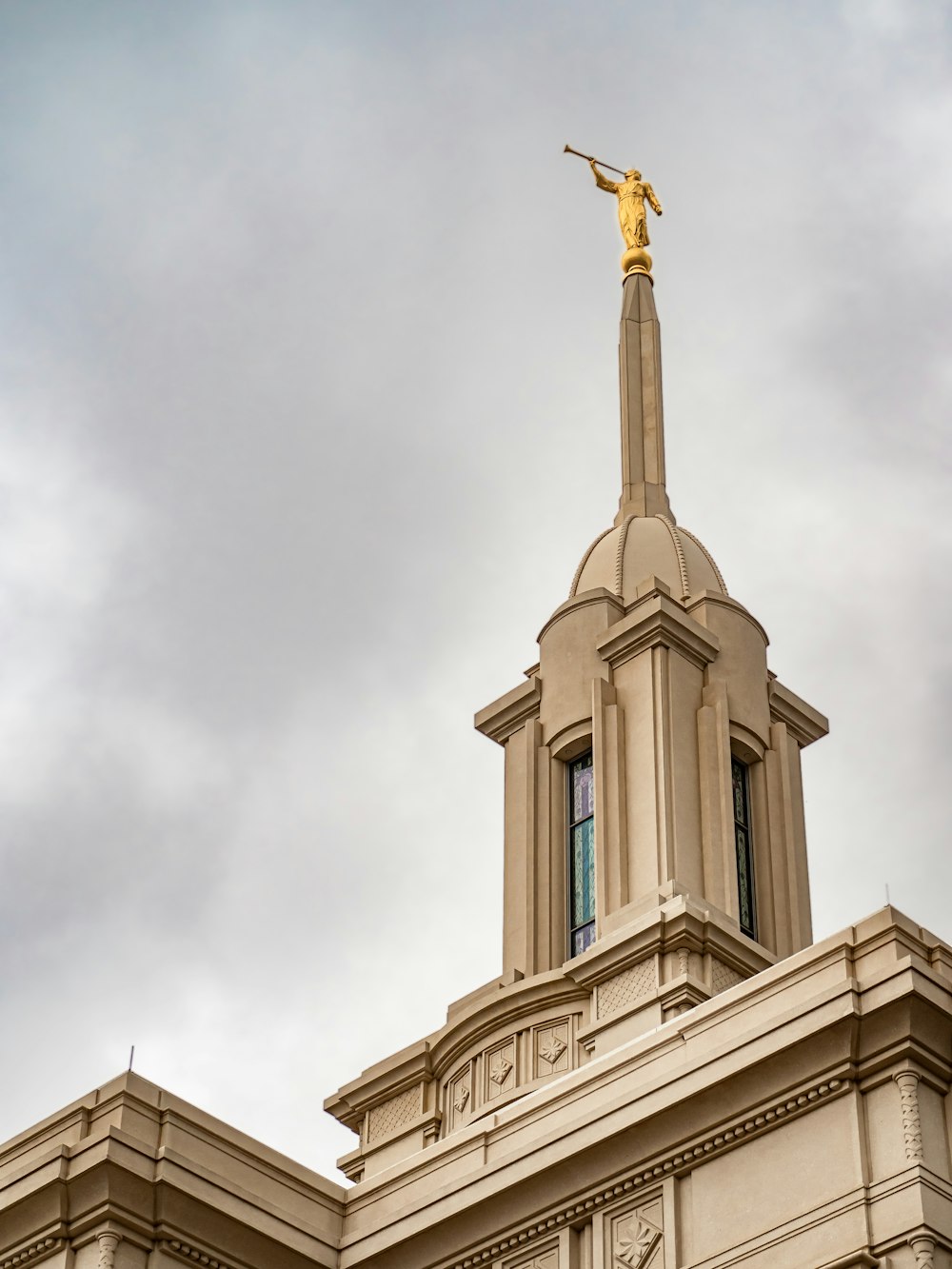 a tall building with a gold statue on top of it