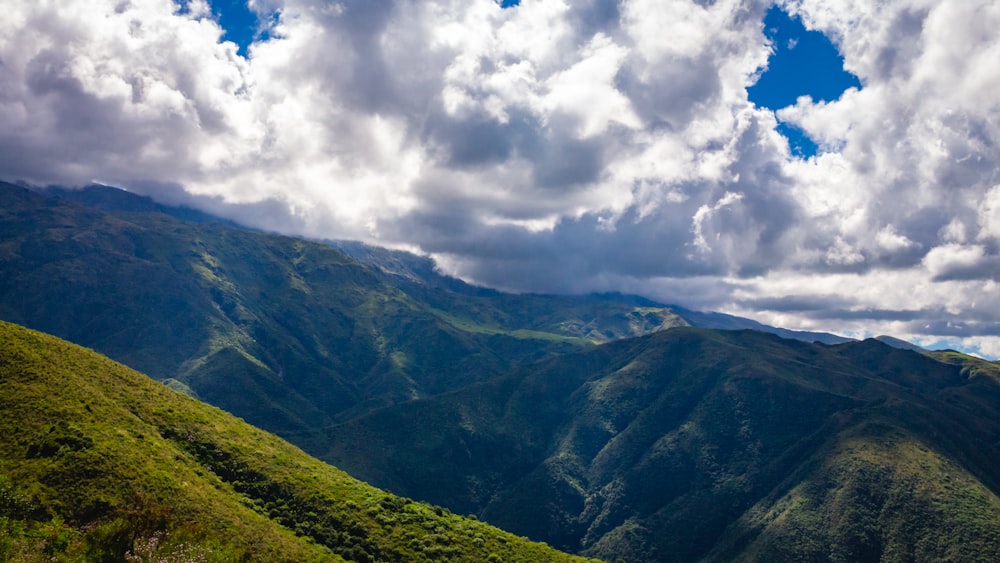 a scenic view of a mountain range under a cloudy sky