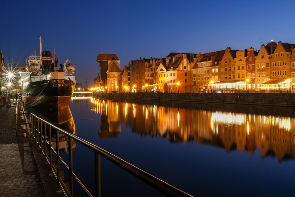 a boat is docked in the water next to some buildings