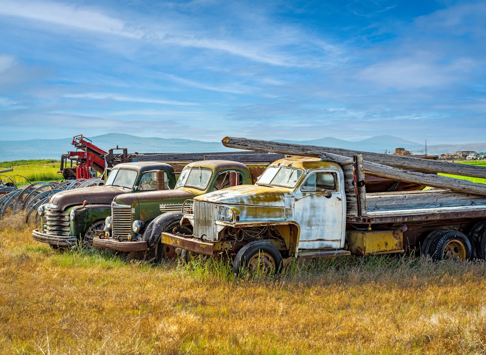 a group of old trucks parked in a field