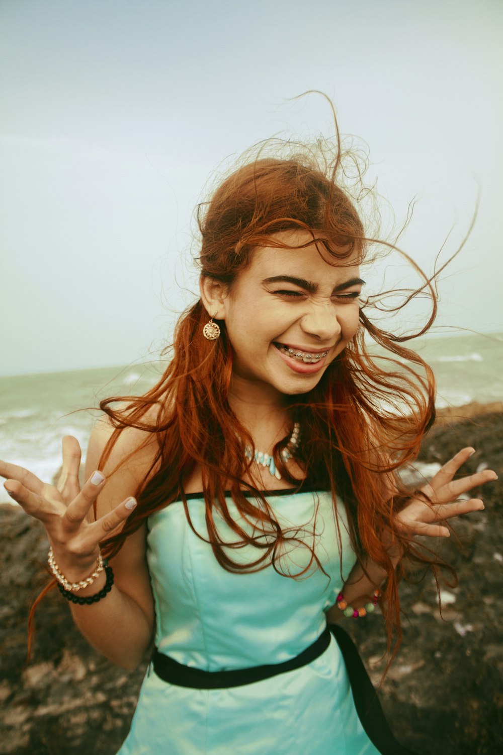 a girl with red hair is smiling and waving