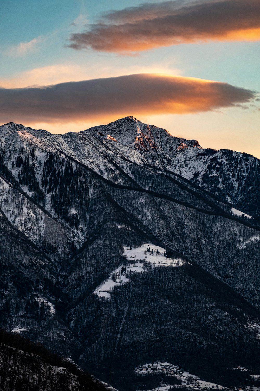 a snow covered mountain with a sunset in the background