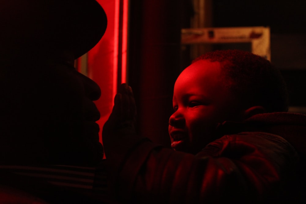 a young child is smiling while being held by a man