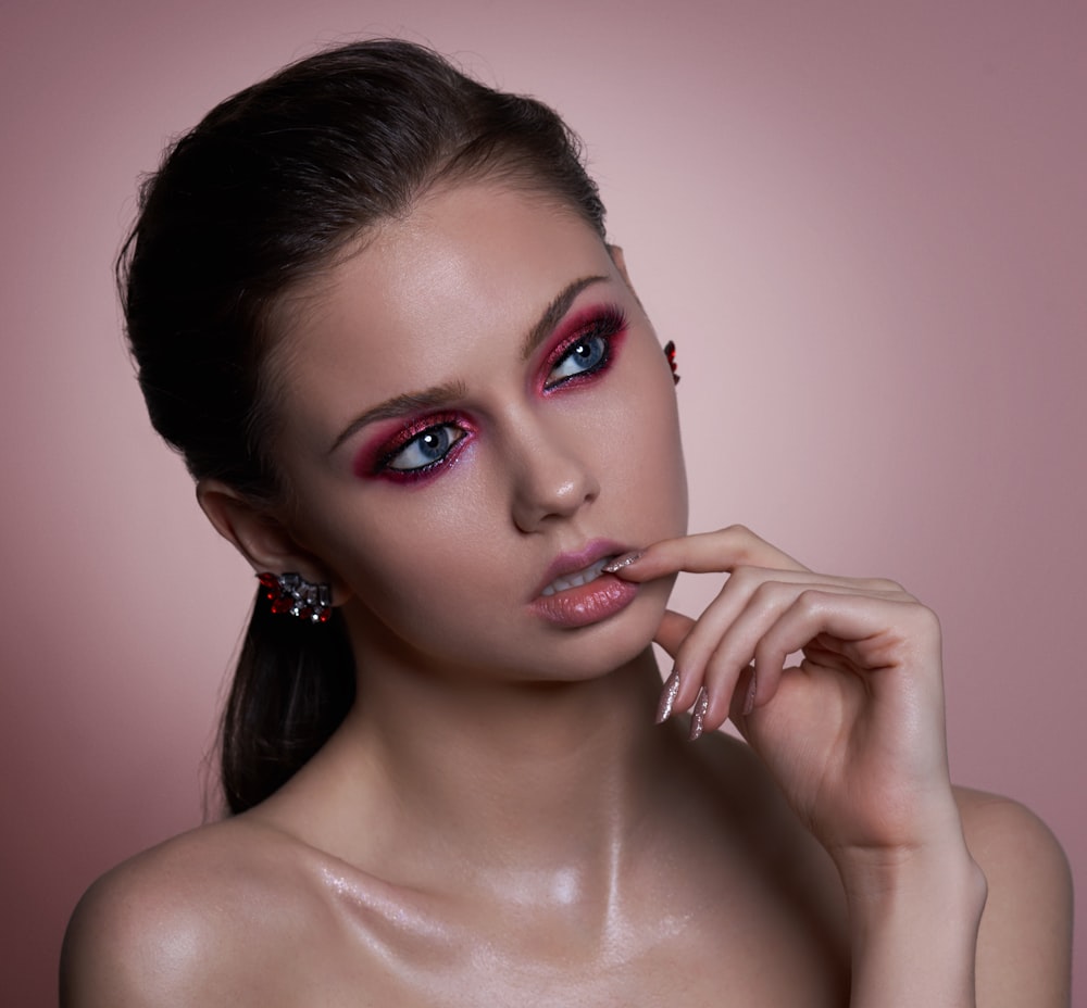 a woman with a pink make up posing for a picture