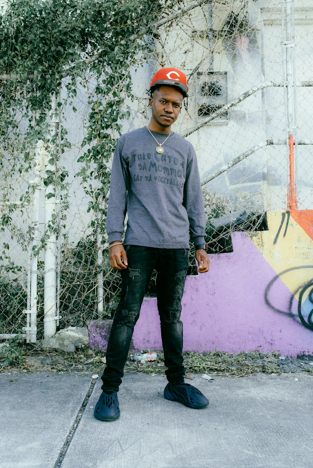 a man standing in front of a graffiti covered wall