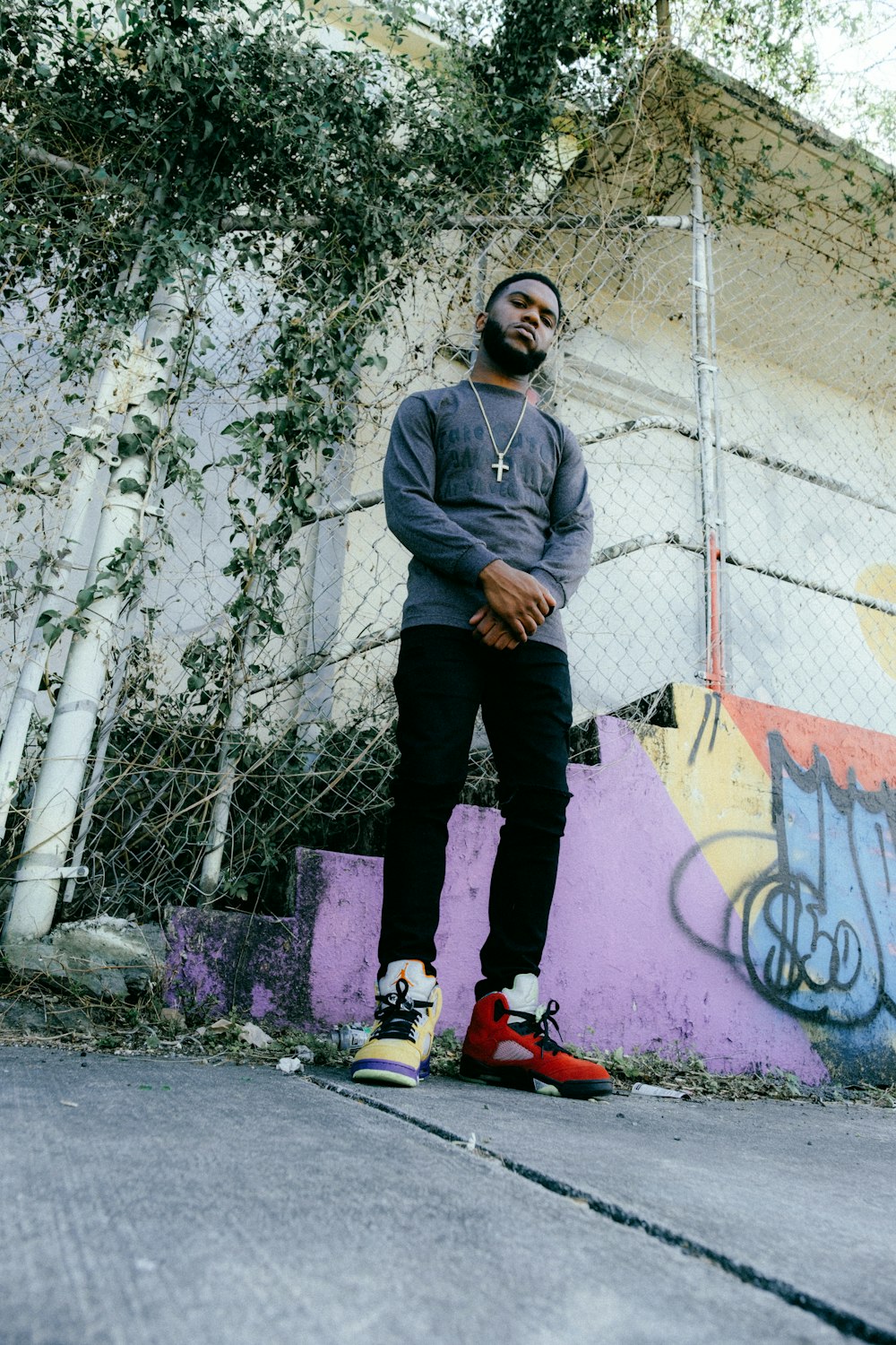 a man standing in front of a graffiti covered wall