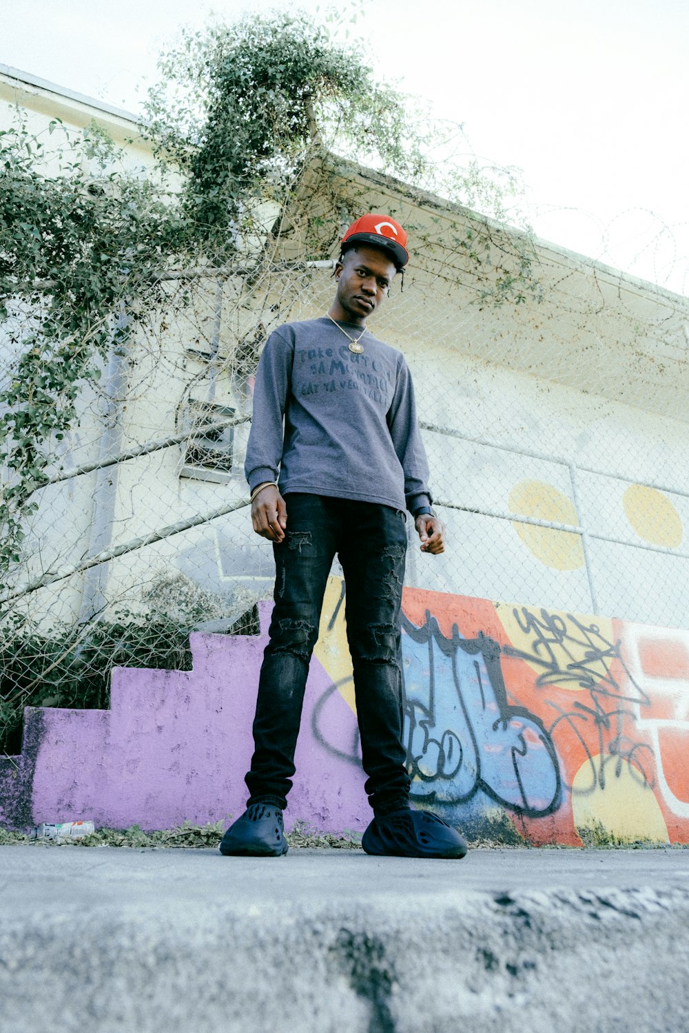 a man standing in front of a graffiti covered wall