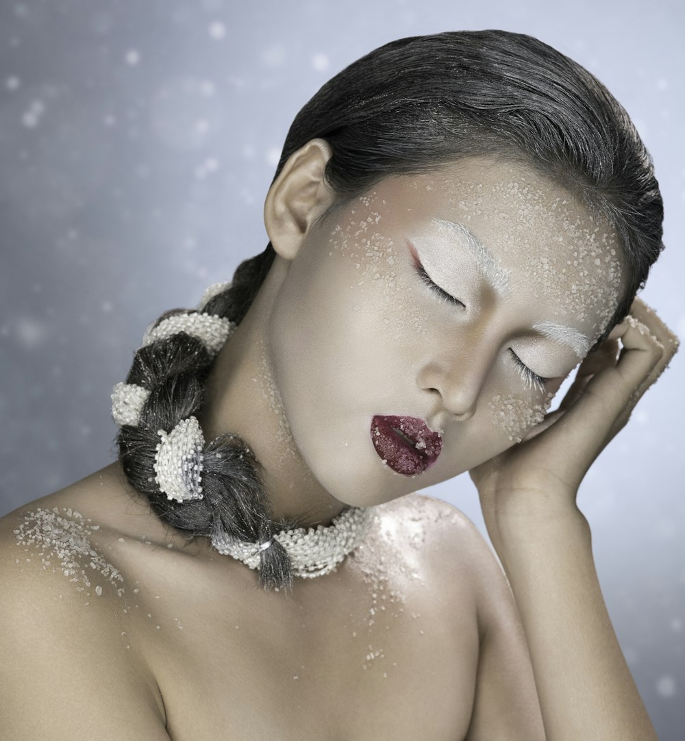 a woman with snow on her face and a braid around her neck
