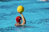 a person in a pool with a ball in their hand