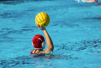 a person in a pool with a ball in their hand