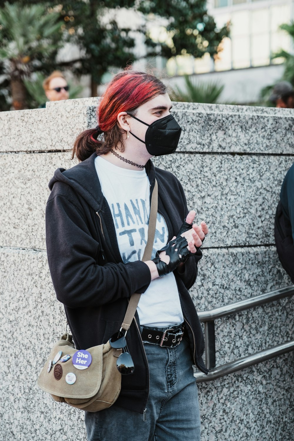 a woman with red hair wearing a face mask