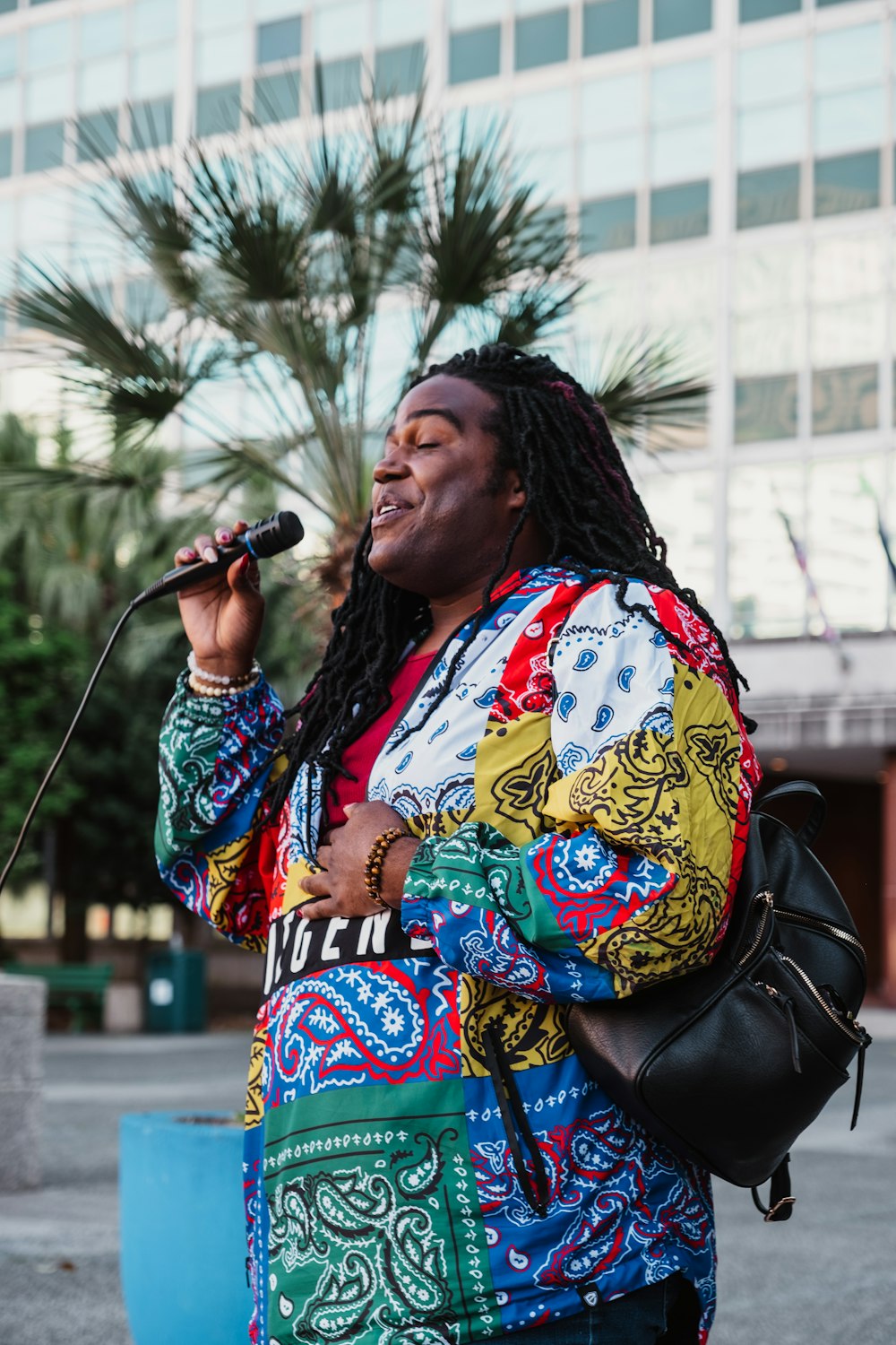 a woman with dreadlocks sings into a microphone