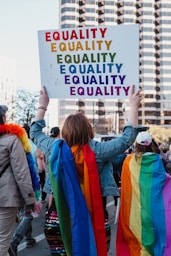 a group of people walking down a street holding a sign