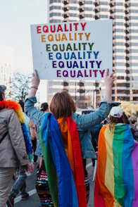 a group of people walking down a street holding a sign