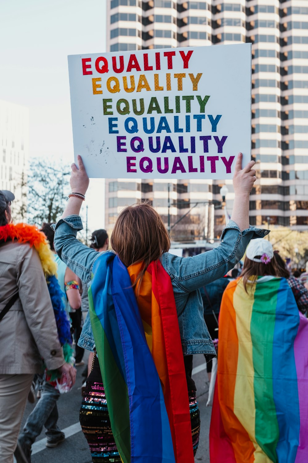 a group of people walking down a street holding a sign