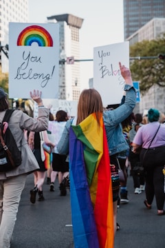 a group of people walking down a street holding signs