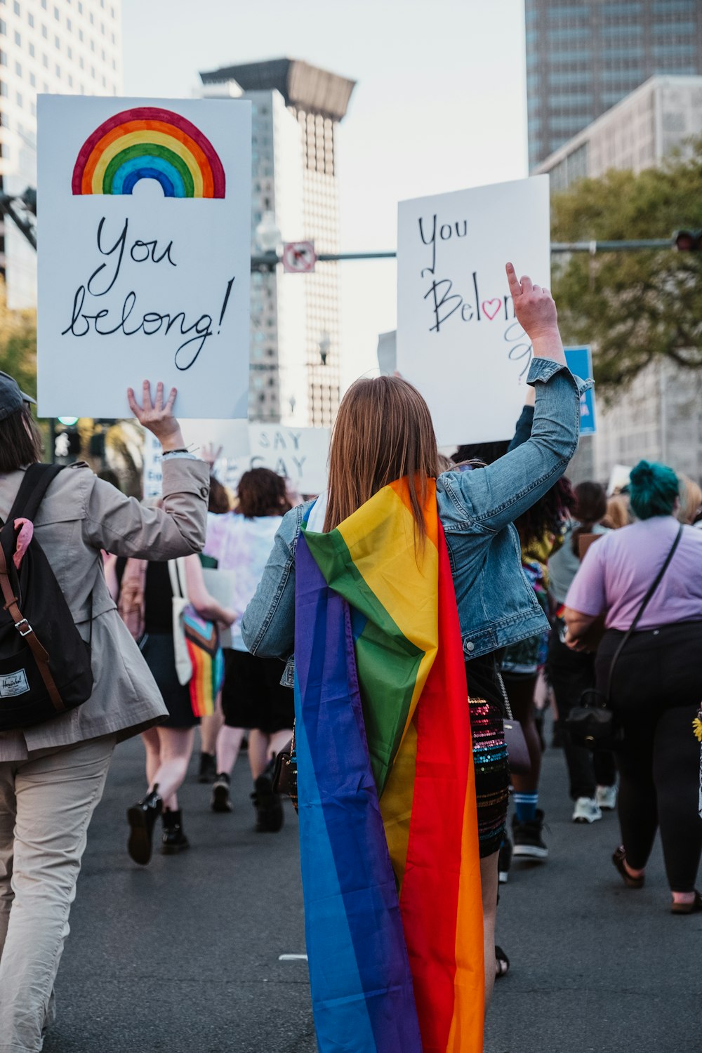 a group of people walking down a street holding signs