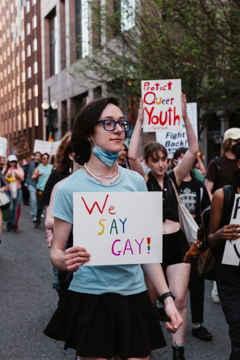a woman holding a sign that says we may gay