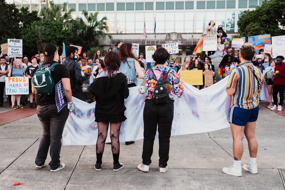 a group of people holding a large white banner