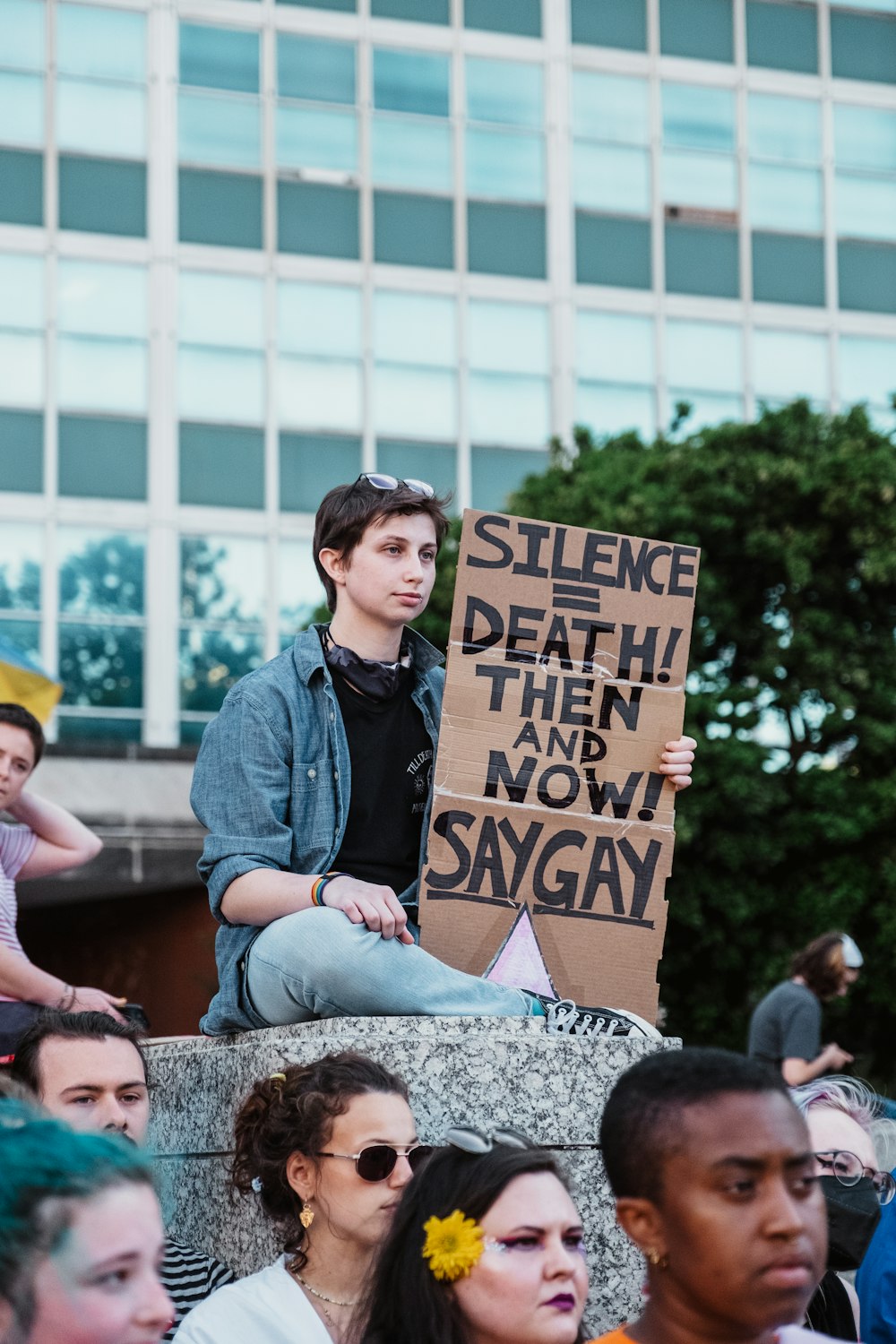 Ein Mann hält ein Schild vor einer Menschenmenge