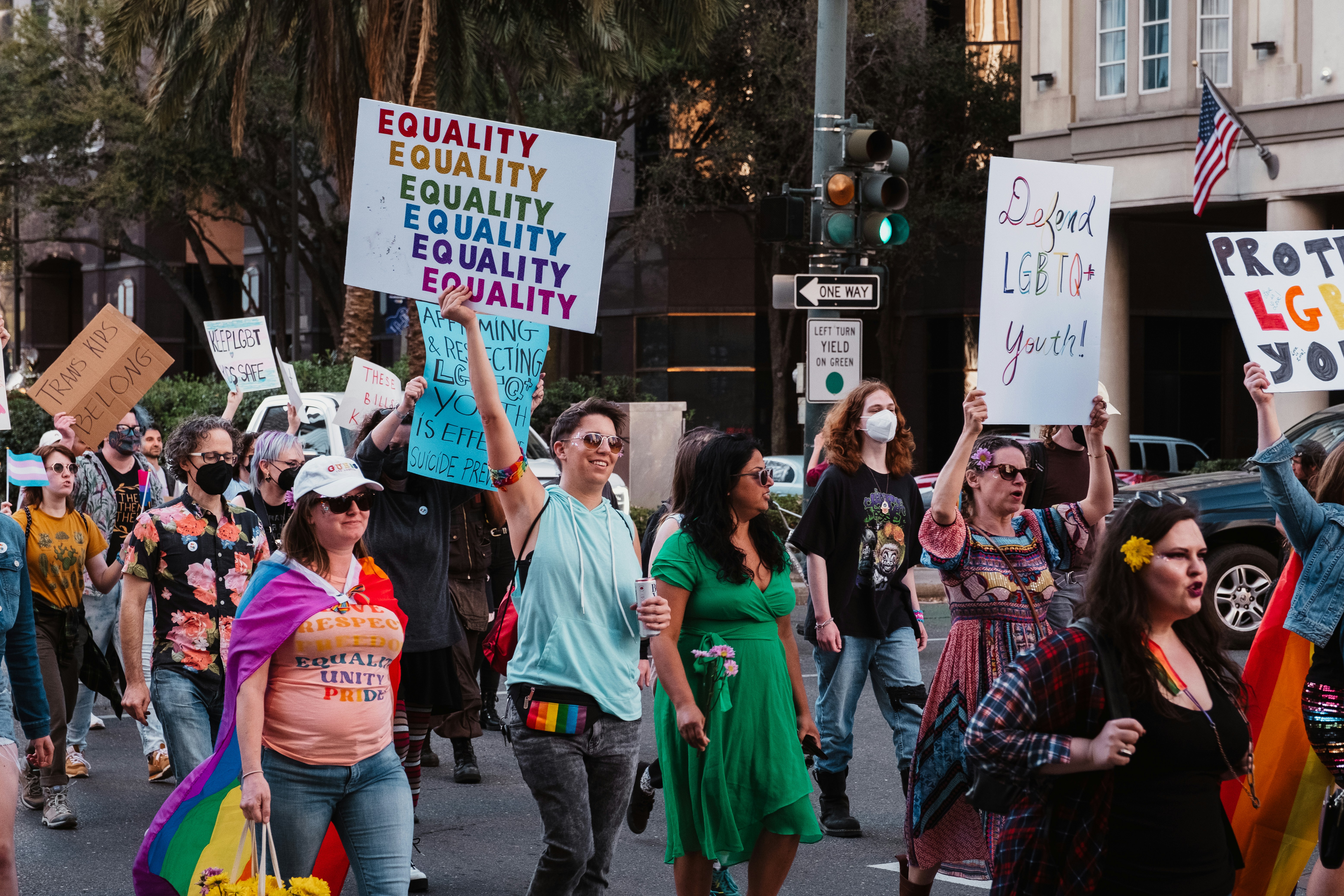 a group of people walking down a street holding signs