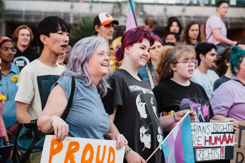 a group of people standing next to each other holding signs