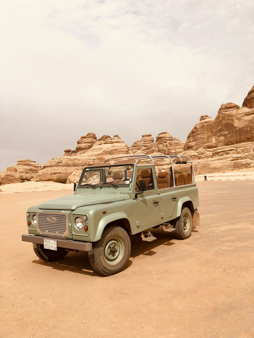 a green pick up truck parked in the desert