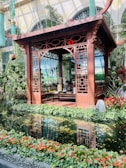Elegant wooden pendopo structure surrounded by lush garden.