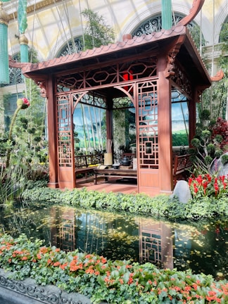 Elegant wooden pendopo structure surrounded by lush garden.